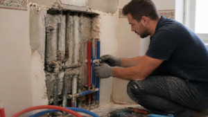 Fontanero realizando el cambio de tuberías en una vivienda de Gijón